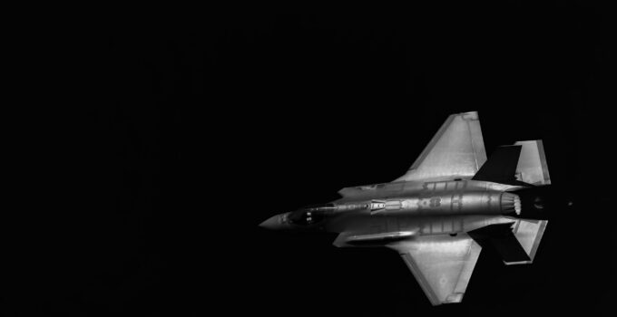 Closeup of a fighter jet pirouetting in the night sky